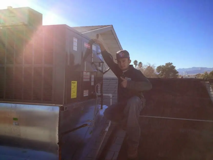 HVAC technician performing HVAC Inspection on a rooftop unit in Taylorsville